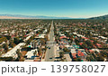 Drone aerial view above Palm Springs city showing long streets residential neighborhoods and distant mountains 139758027