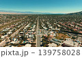 Aerial drone shot of Palm Springs main road stretching through desert city with residential districts and mountains 139758028