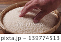 特寫鏡頭：一隻手輕輕撫摸著盛在竹籃裡的純白米飯。 139774513