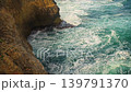 Sea crashing on rocky shore, green water splashing and creating white foam, view from above, slow motion video 139791370