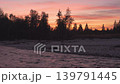 Evening scene at the river, silhouettes of trees at the rocky shore with sunset coloured sky background 139791445