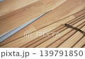 Installing laminated floor, detail on wooden tile fitted, over white foam base layer, small pile with more tiles near 139791850