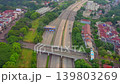 High-angle aerial drone footage showing a toll gate and multi-lane highway interchange in an urban area of Indonesia.  139803269