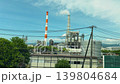 Industrial factory complex with smoking chimneys and manufacturing structures under a clear blue sky in April. Scenic view of the majestic Mount Fuji in spring from a moving Tokaido Shinkansen train. 139804684