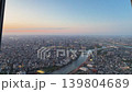 Aerial high-angle footage captures a panoramic evening view of Tokyo city from the Tokyo Skytree observation deck. The camera overlooks the winding Sumida River. 139804689