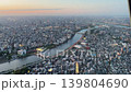 Aerial high-angle footage captures a panoramic evening view of Tokyo city from the Tokyo Skytree observation deck. The camera overlooks the winding Sumida River. 139804690