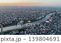 Aerial high-angle footage captures a panoramic evening view of Tokyo city from the Tokyo Skytree observation deck. The camera overlooks the winding Sumida River. 139804691