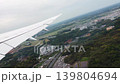 Passenger airliner taking off from Tokyo airport heading to Toronto. Commercial airplane flying over Japanese landscape during daytime ascension.  139804694