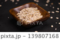 bowl with oatmeal flakes for making porridge, scattered dry cereal flakes from oats, flattened, steamed and dried, close up 139807168