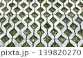 Decorative sidewalk made of figured grey concrete tiles in the shape of diamonds. 139820270
