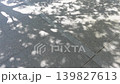 Sunlight filtering through trees reflected on paving stones; an abstract background of fluctuating natural light. 139827613
