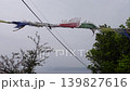 Five-colored prayer flags and cherry blossoms fluttering in the wind against the backdrop of the sea. 139827616