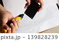 Close Up of Hand Using Portable Electric Drill to Make Screw Hole on Black Plastic Component 139828239