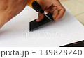 Close Up of Hand Using Portable Electric Drill to Make Screw Hole on Black Plastic Component 139828240