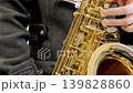 特寫鏡頭：演奏次中音薩克斯風的人，身穿灰色外套。 139828860