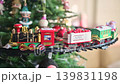4K Toy train running on circular track around decorated christmas tree 139831198