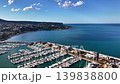 Aerial marina coastline turquoise sea view sunlit harbor filled with yachts and boats, clear blue sky 139838800