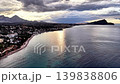 Aerial resort coastline at sunset, golden turquoise shallows beachfront promenade cluster of buildings, 139838806