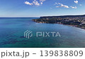 Aerial turquoise bay coastline clear water shimmering under sun drone survey captures coral patches 139838809