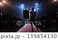 Beautiful female painter silhouette standing near easel in dramatic stage lighting 139854130