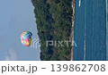 Thailand, Phuket, a parachute with people attached to the boat, the edge of pool side with view on the sea at sunny day, sun umbrella, pleasure boat on background 139862708