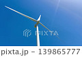 Tall Wind Turbine Against Clear Blue Sky 139865777