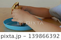 Close-up of a boy's hands holding a bitten chicken burger with a golden bun 139866392