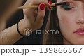 Close-up of a makeup artist painting the eyes of a beautiful brunette. 139866567