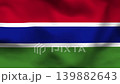 Gambia flag on wavy fabric, top view. Realistic textile with red, blue, and green stripes separated by white borders 139882643