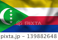 Comoros flag on wavy fabric, top view. Realistic textile with yellow, white, red, and blue stripes and a green triangle with crescent. 139882648
