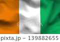 Cote dIvoire flag on wavy fabric, top view. Realistic silk texture with orange, white, and green vertical stripes. 139882655