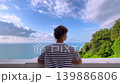 Woman is looking at the Black Sea, green trees and blue cloudy sky 139886806