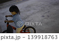 Toddler Learning To Ride Balance Bike, A heartwarming video of a toddler taking first steps on a balance bike, capturing early confidence and determination, perfect for family lifestyle documentary. 139918763