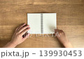 A child's hand turning the pages of a small ring notebook in 4K slow motion. 139930453