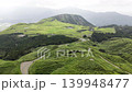 Aerial footage of the green plateau and winding roads in Minami-Aso, Kumamoto Prefecture. 139948477