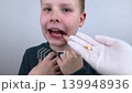 10 year old boy at pediatric dentist showing milk tooth extraction. Concept of caries treatment, physiological change of teeth and permanent teeth eruption in school age children. 10 year old boy at pediatric dentist showing milk tooth extraction. Concept of caries treatment, physiological change of teeth and permanent teeth eruption in school age children. 139948936