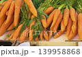 Orange carrots and leafy greens display 139958868