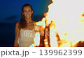 A girl looks at a beautiful bonfire on the ocean beach at a hotel on a tropical island 139962399