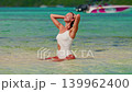 A concept of luxury vacation, freedom, beauty and tropical travel lifestyle. Ideal for summer promo content. View of woman walking along a tropical coastline. Mauritius 139962400