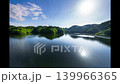 Nunome Dam in early summer 2026: The blue sky and a path of light reflected on the surface of the lake, which is filled to the brim with water. 139966365