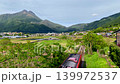 「豊後富士」とも称される美しい由布岳のふもと由布院駅へ赤い列車が向かう 139972537