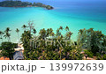 Cinematic aerial drone view of tropical palm coastline and turquoise ocean water on Koh Kood island in Thailand during sunny summer day. 139972639