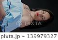 Fashionable woman wearing red glasses posing with hand on necklace. Stylish eyewear model portrait. 139979327