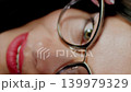 Closeup of woman holding glasses and looking intensely through the frames. Vision check and optical focus. 139979329