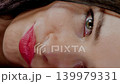 Playful woman biting the earpiece of her colorful glasses. Thinking or flirting concept with eyewear. 139979331