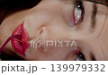 Close up of woman playfully biting glasses frame with a thoughtful expression. Fun eyewear and fashion portrait. 139979332