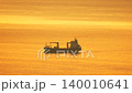 Cargo ship, sunset, ocean Freighter vessel cruises across the calm golden sea during beautiful warm evening light 140010641