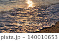 Sunset ocean beach, golden waves washing ashore, serene evening landscape, beautiful natural scene 140010653