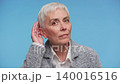 Senior woman listening carefully with hand by ear on blue 140016516