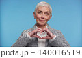 Senior woman making heart shape with hands 140016519